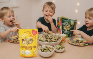 Die Kinder essen gemeinsam Fischsnacks.